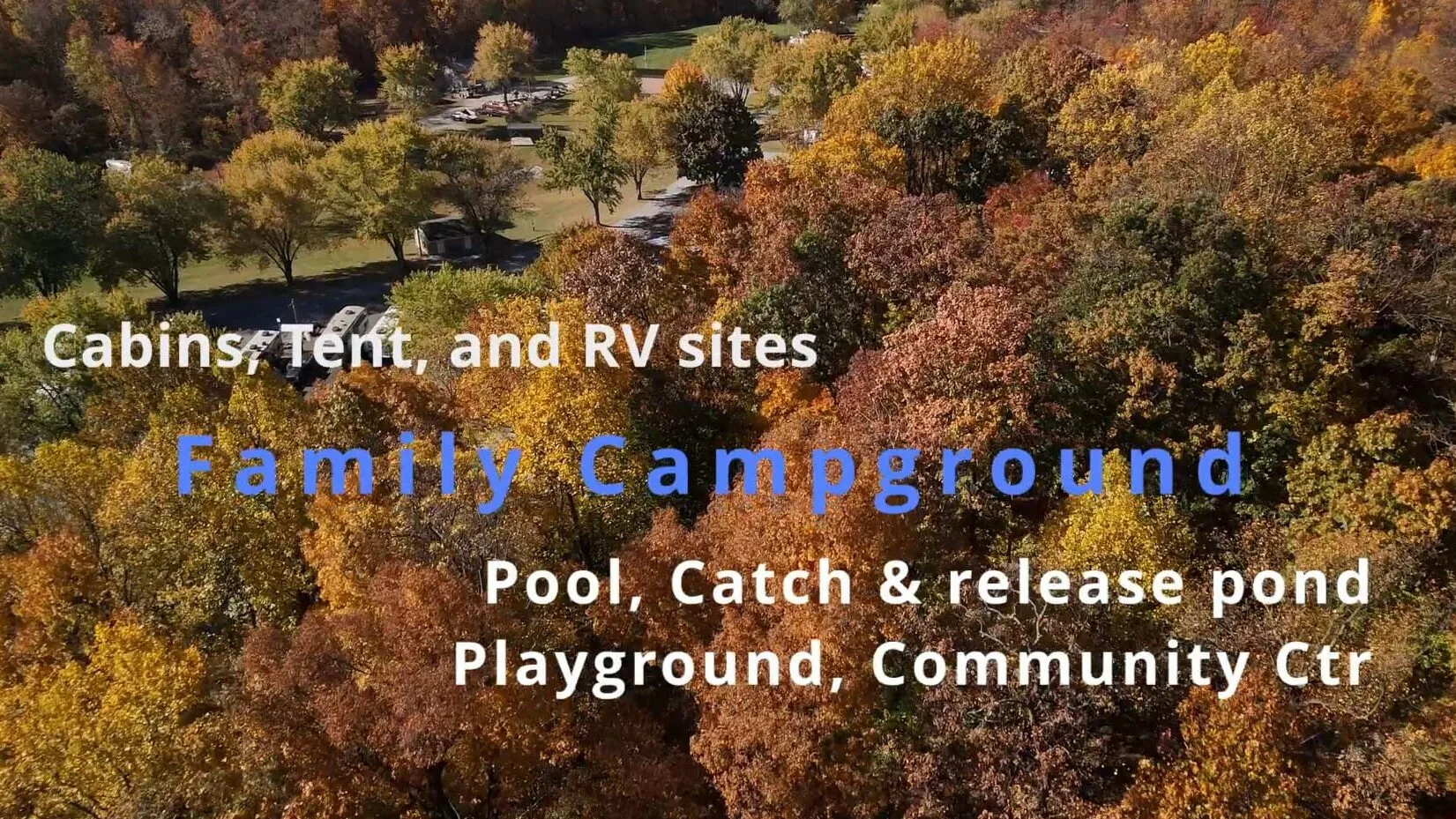 Fall colored trees with a road and vehicles toward the background and the text "Canins, Tent, and RV sites; Fanily Campground; Pool, Catch & release pond; Playground, Community Ctr" on the picture.